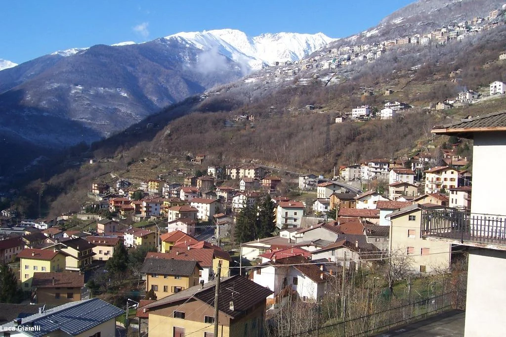 Veduta di Demo nel fondovalle e Berzo sul versante della montagna.