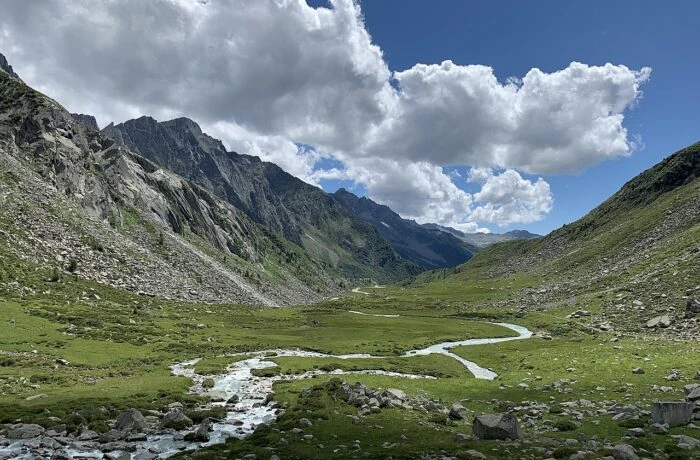 Il paesaggio reale della Valle Adamè, tra prati, torrente e montagne